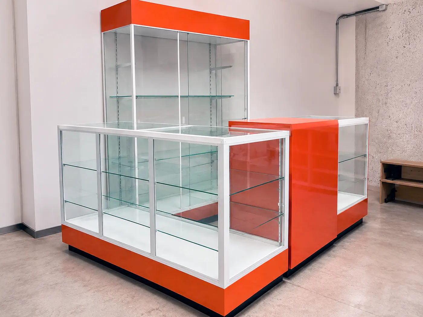 Isla y vitrina comercial naranja de cristal para exhibición de productos.